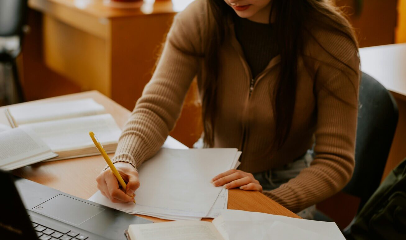 Hochbegabte_Frau_am_Computer Junge hochbegabte Frau beim Lernen am Computer mit Buch und Notizen – zwischen Genie und Selbstzweifel.